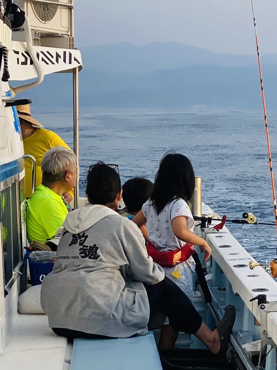 朝もやの中、下田港からポイントへ向かう船上の親子とチーム立釣魂スタッフ