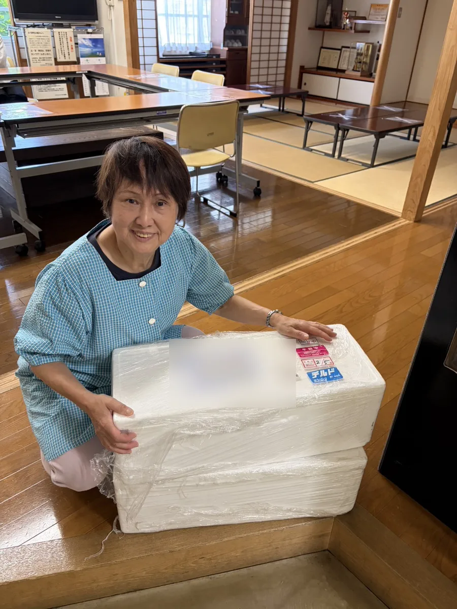 Children's cafeteria staff receiving the two foam boxes of marlin